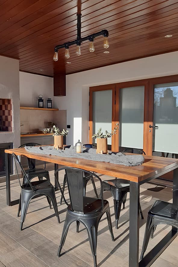 Terraza cubierta con mesa larga de comedor