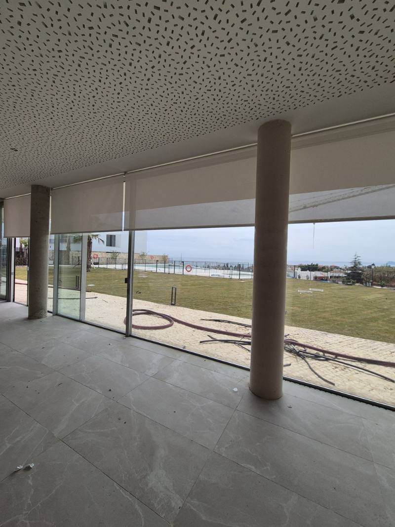 Zona común con estores enrollables y vistas al jardín